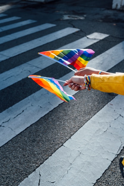 Las manos de mujeres con una bandera del orgullo gay