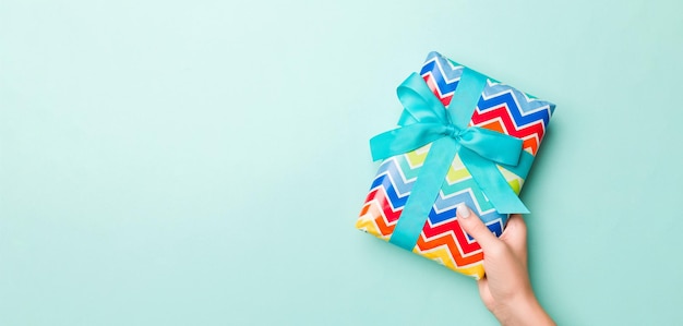 Foto las manos de las mujeres dan regalos de navidad envueltos u otros regalos de vacaciones hechos a mano en cajas de regalos de papel de colores