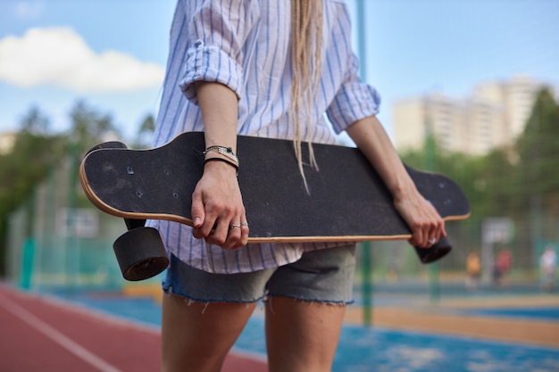 Las manos de las mujeres de la foto sostienen una sesión de fotos de deportes de longboard foto de alta calidad del deporte moderno