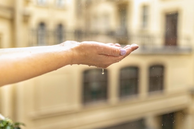 Las manos de las mujeres en la lluvia las gotas de lluvia caen en sus manos atrapan