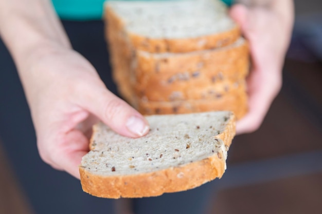 Las manos de las mujeres sosteniendo rebanadas de pan de cerca el proceso de preparación de sándwiches frescos