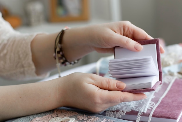 Las manos de las mujeres sostienen un papel de inscripción Merry cristmass Scrapbucing