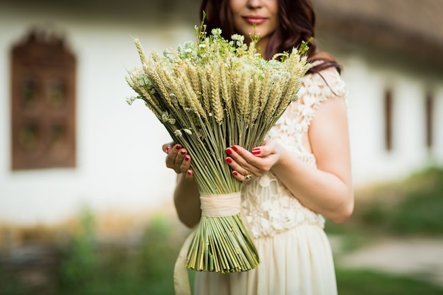 Las manos de las mujeres sostienen un ramo de flores secas y orejas en zonas rurales