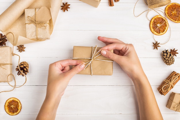 Las manos de las mujeres sostienen un regalo de papel artesanal.