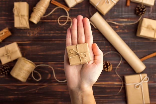 Las manos de las mujeres sostienen un regalo de papel artesanal.