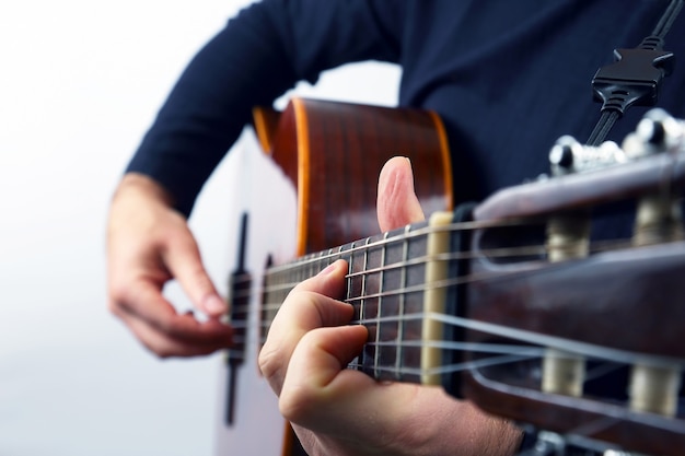 Manos del músico tocando la guitarra clásica