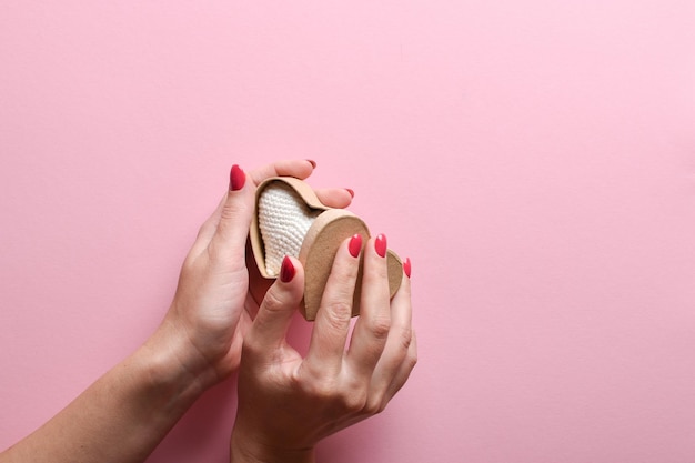 Las manos de la niña abren una ecocaja en forma de corazón Un regalo para San Valentín