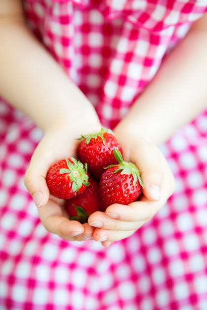 Manos de niña con fresas