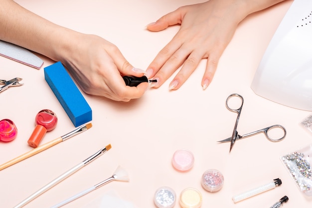 Manos de una niña haciendo una manicura en casa, primer plano de las manos