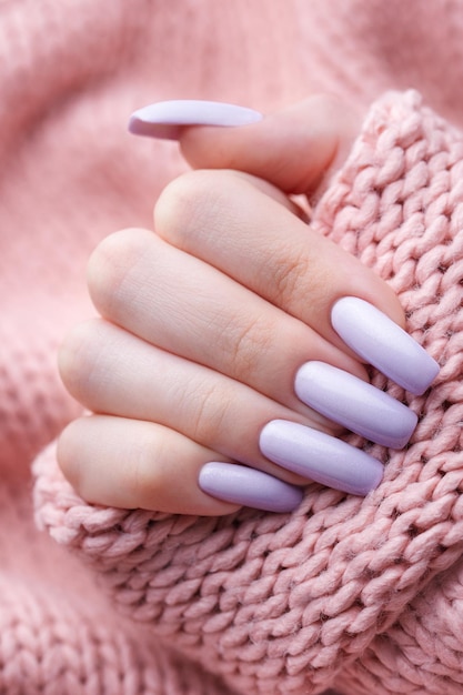 Foto manos de niña con una manicura morada suave