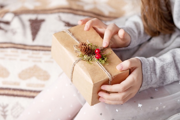 Manos de niña sosteniendo caja de regalo. Copie el espacio.