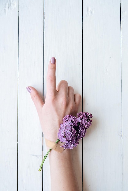 Manos de una niña con un yeso médico con concepto de flores lilas higiene de la salud de la mujer