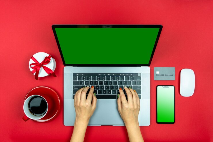Foto manos de niñas con laptop taza de café roja con tarjeta de crédito de teléfono y regalo compras de regalos en línea