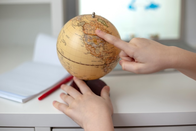 Foto las manos del niño atraviesan el globo con un dedo. de cerca