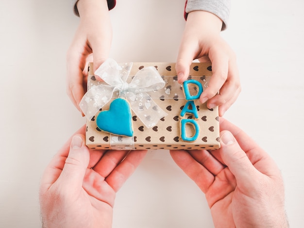 Manos de niño y una bonita caja de regalo.