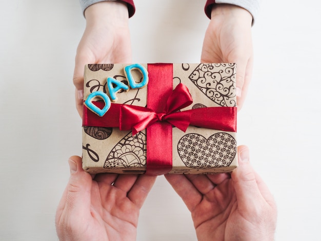 Manos de niño y una bonita caja de regalo.