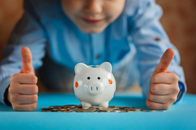 Manos niño y hucha o caja de dinero.