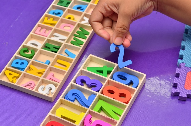 Foto manos del niño jugando con el alfabeto