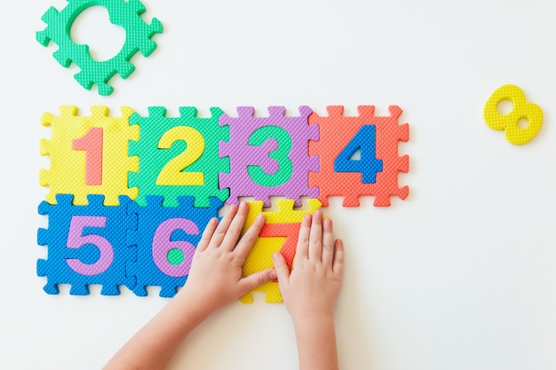 Foto manos del niño jugando con números, aprendiendo multiplicación simple