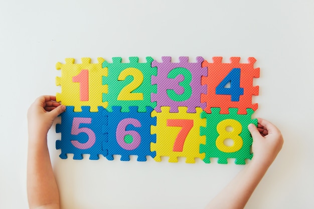 Manos del niño jugando con números, aprendiendo multiplicación simple