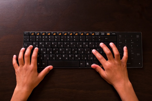 Manos de niño negro con teclado.