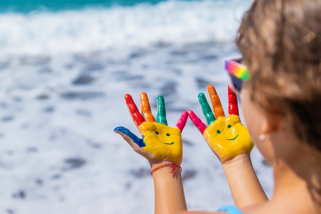 Manos de niño pintadas con pinturas sobre el mar. Enfoque selectivo. Niño.