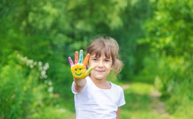 Las manos del niño pintan una sonrisa.