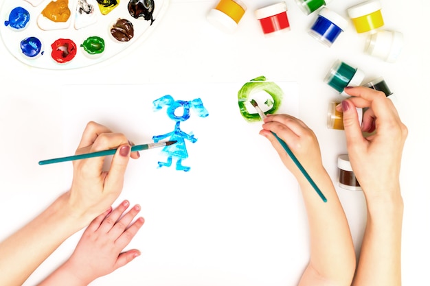 Las manos del niño pintando una familia