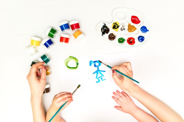 Las manos del niño pintando una familia