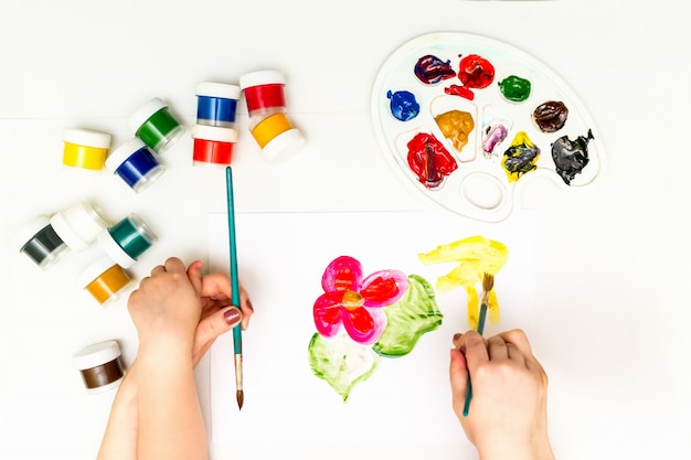 Las manos del niño pintando una flor