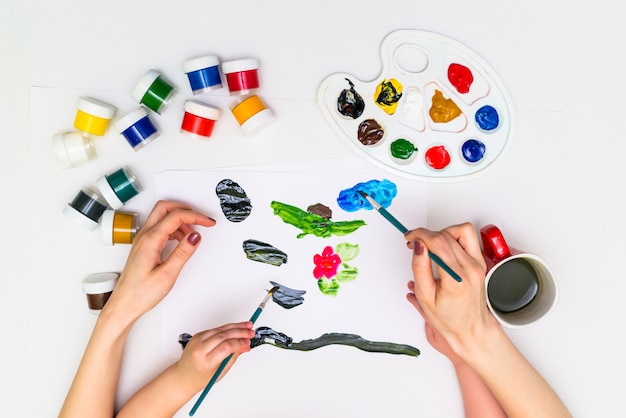 Las manos del niño pintando una flor