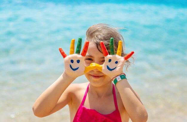 En las manos del niño, una sonrisa con pinturas sobre el mar.