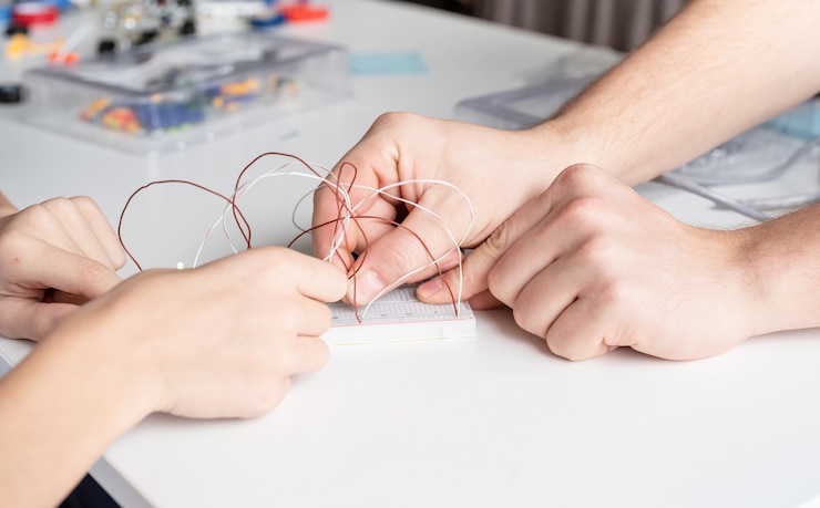 Foto manos de niño trabajando con luces led en placa experimental para proyecto científico