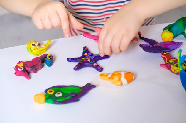 Manos de niños y artesanías hechas de plastilina.