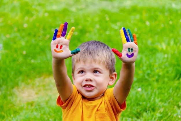 Manos de niños en los colores del verano una sonrisa en la palma del niño.