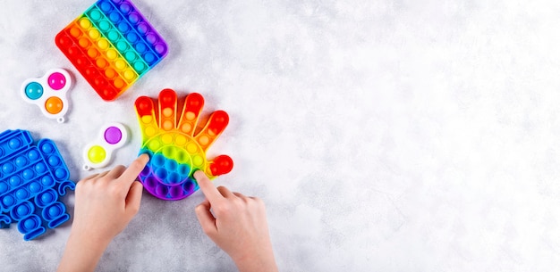 Las manos de los niños están jugando un nuevo juguete de silicona de moda