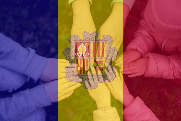 Manos de niños en el fondo de la bandera de Andorra Concepto de unidad y patriotismo andorrano