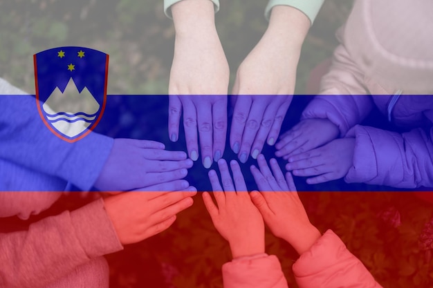 Foto manos de niños en el fondo de la bandera de eslovenia concepto de unidad y patriotismo esloveno