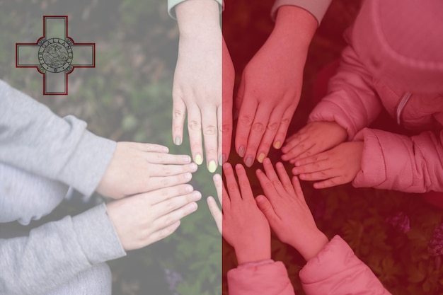 Manos de niños en el fondo de la bandera de Malta Concepto de unidad y patriotismo maltés