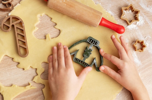 Manos de niños con galletas de pan de jengibre en fondo de madera