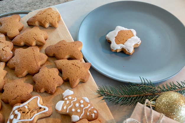 Las manos de los niños hacen galletas de jengibre de Año Nuevo en una mesa de madera. Hacer galletas con un cortador de galletas. Concepto de Navidad y año nuevo.