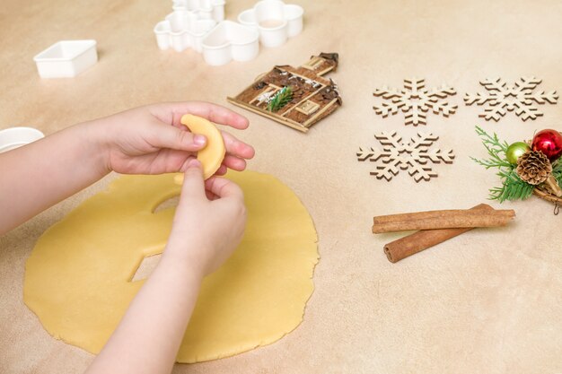 Las manos de los niños hacen galletas de navidad