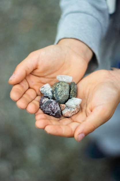 manos de los niños piedras fondo gris