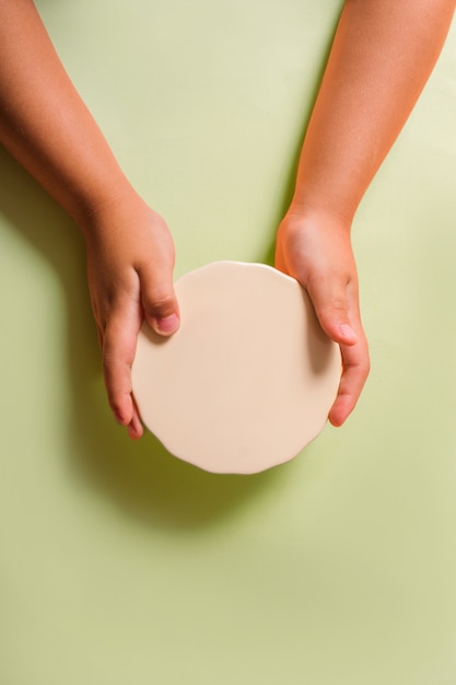 Manos de los niños sosteniendo un plato de pastel