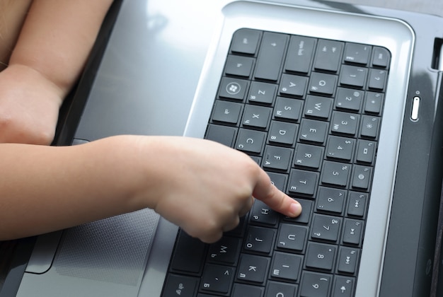 Manos de niños en el teclado del portátil