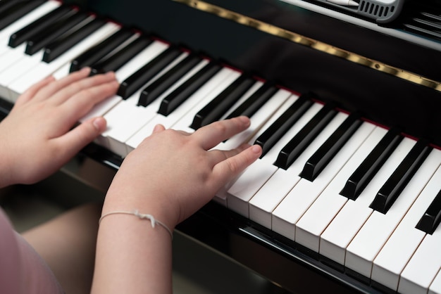 Las manos de los niños tocan la tecla del piano