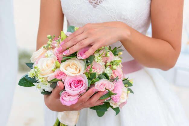 Las manos no están en un ramo de rosas blancas y rosadas.