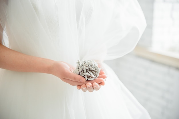 Manos de novia con manicura en guantes de encaje blanco