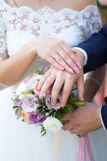 Manos de la novia y el novio en el ramo de la boda