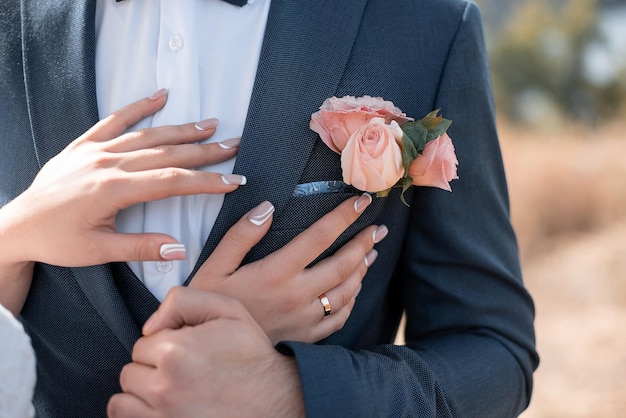 Manos de la novia en los ojales del novio decoración de bodas con flores para agencias de eventos